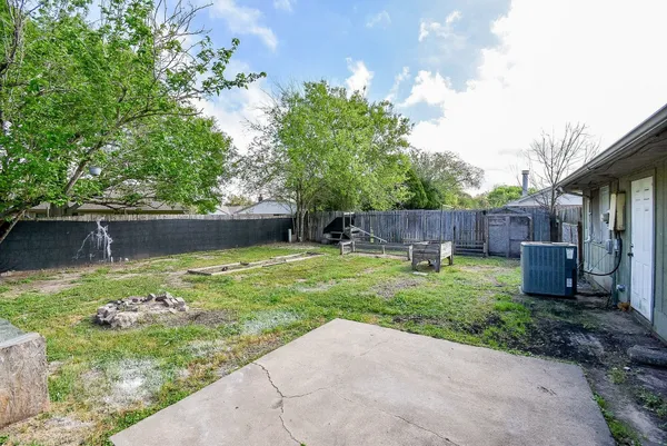 a view of backyard with potted plants and wooden fence