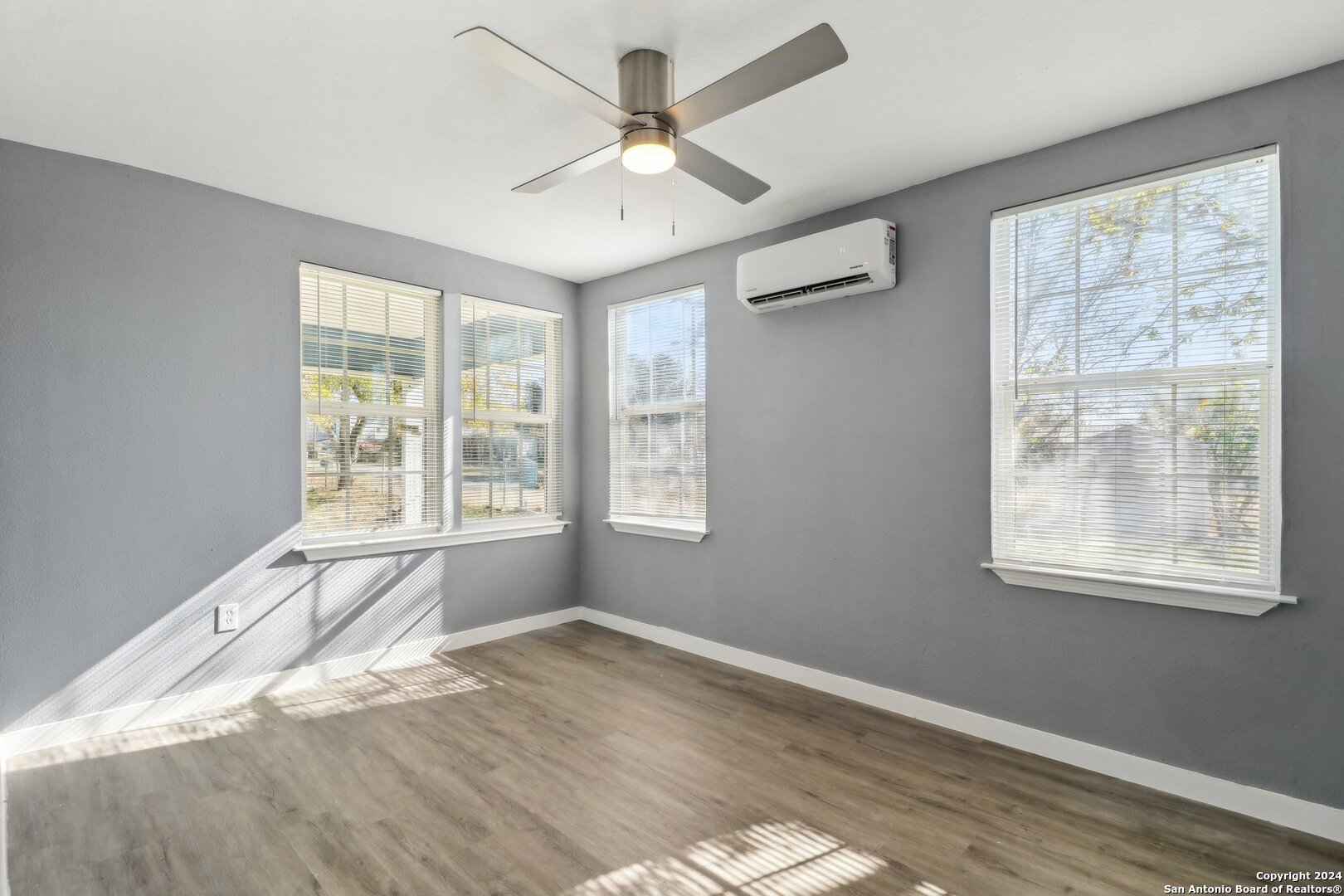 132 Renfro Drive Devine, TX 78016 - Photo 11 of 36 a view of an empty room with wooden floor and a window