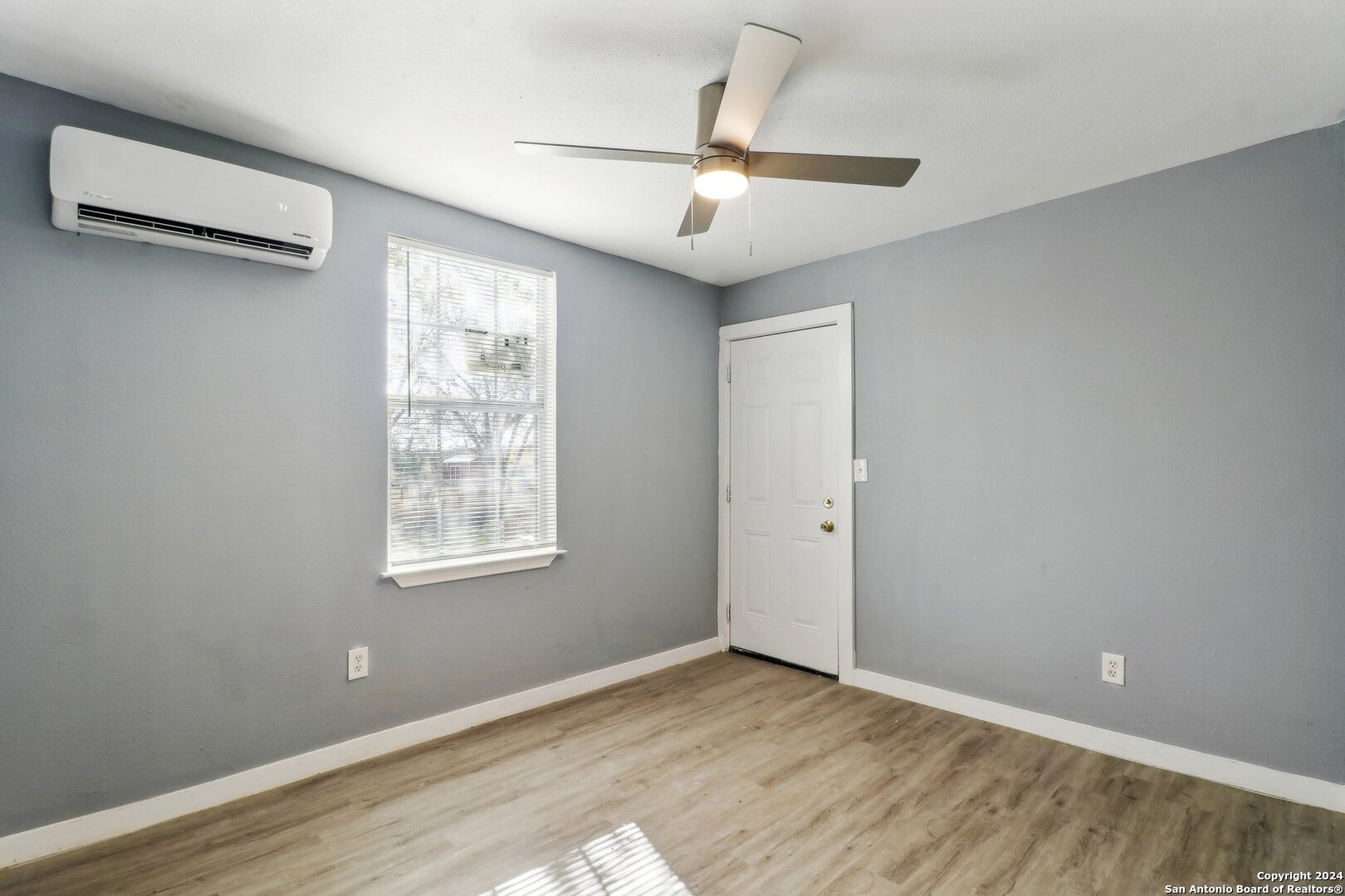 132 Renfro Drive Devine, TX 78016 - Photo 13 of 36 a view of an empty room with wooden floor and a window
