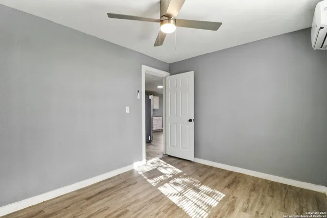 a view of a room with wooden floor and a ceiling fan