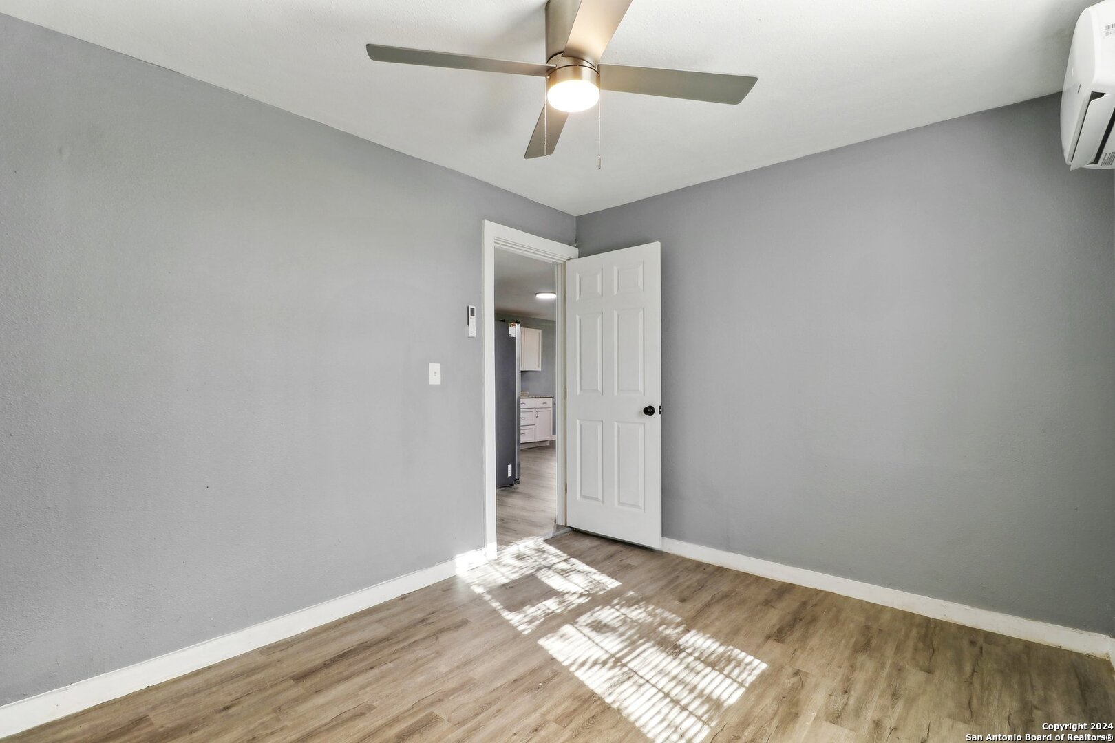 132 Renfro Drive Devine, TX 78016 - Photo 14 of 36 a view of a room with wooden floor and a ceiling fan