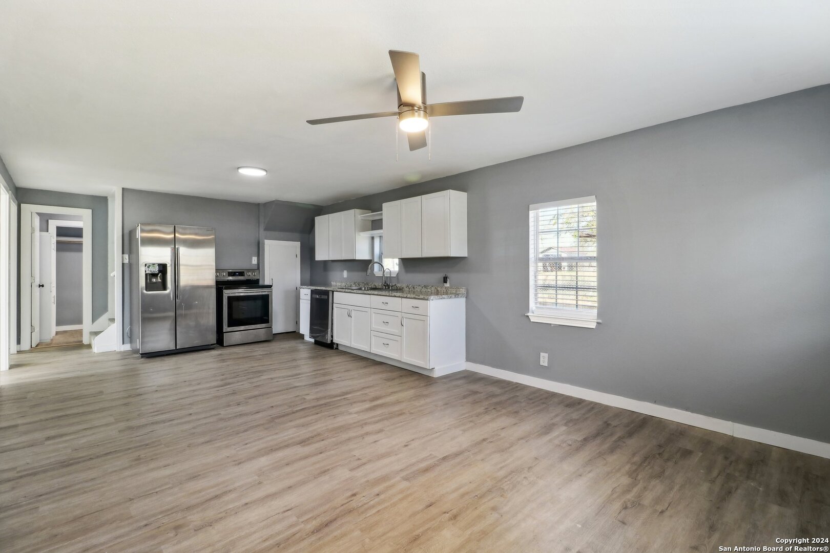132 Renfro Drive Devine, TX 78016 - Photo 7 of 36 a view of a kitchen with a sink dishwasher cabinets and a large window