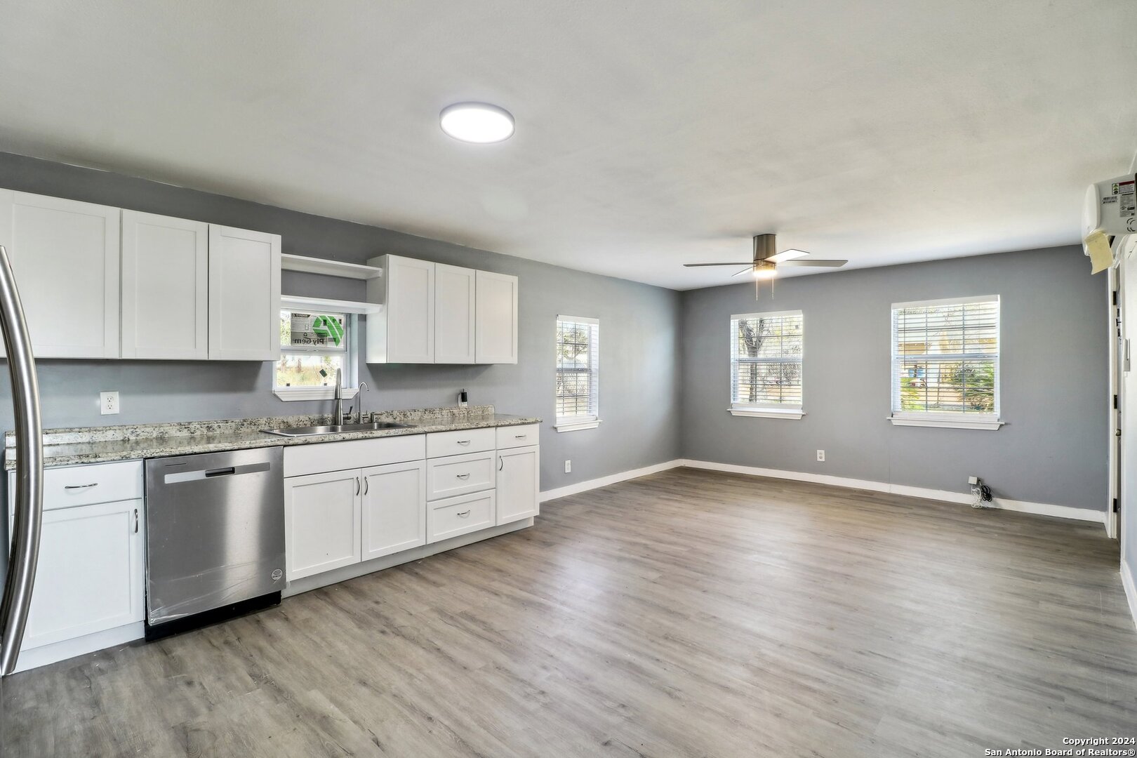 132 Renfro Drive Devine, TX 78016 - Photo 10 of 36 a open kitchen with granite countertop white cabinets and wooden floor