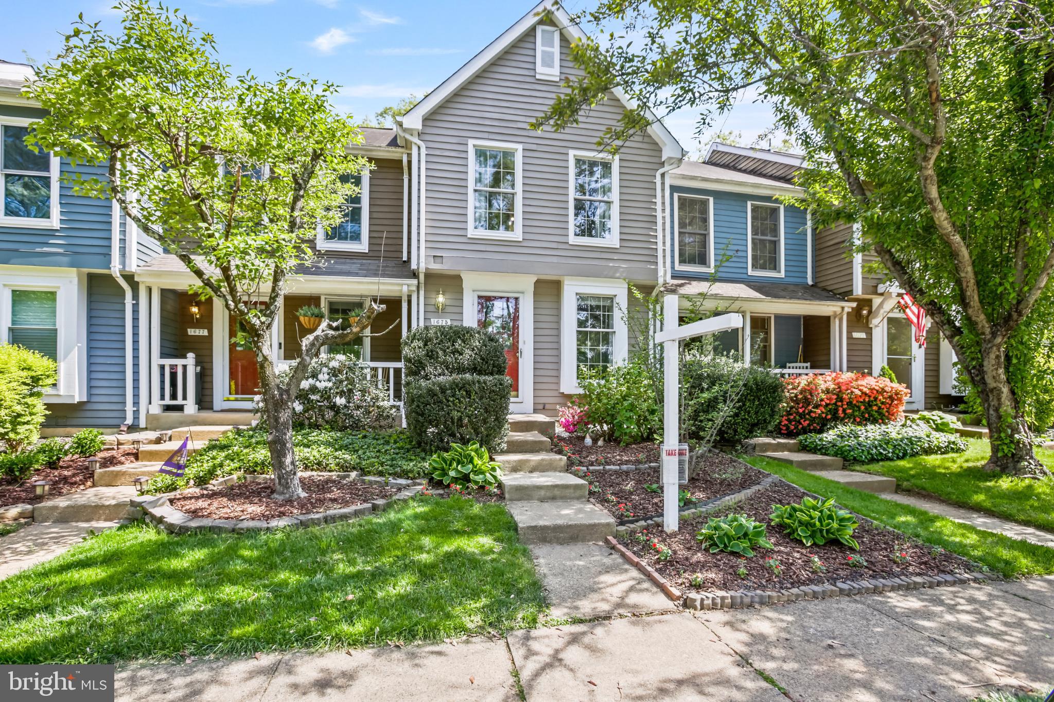 a front view of a house with a yard and potted plants