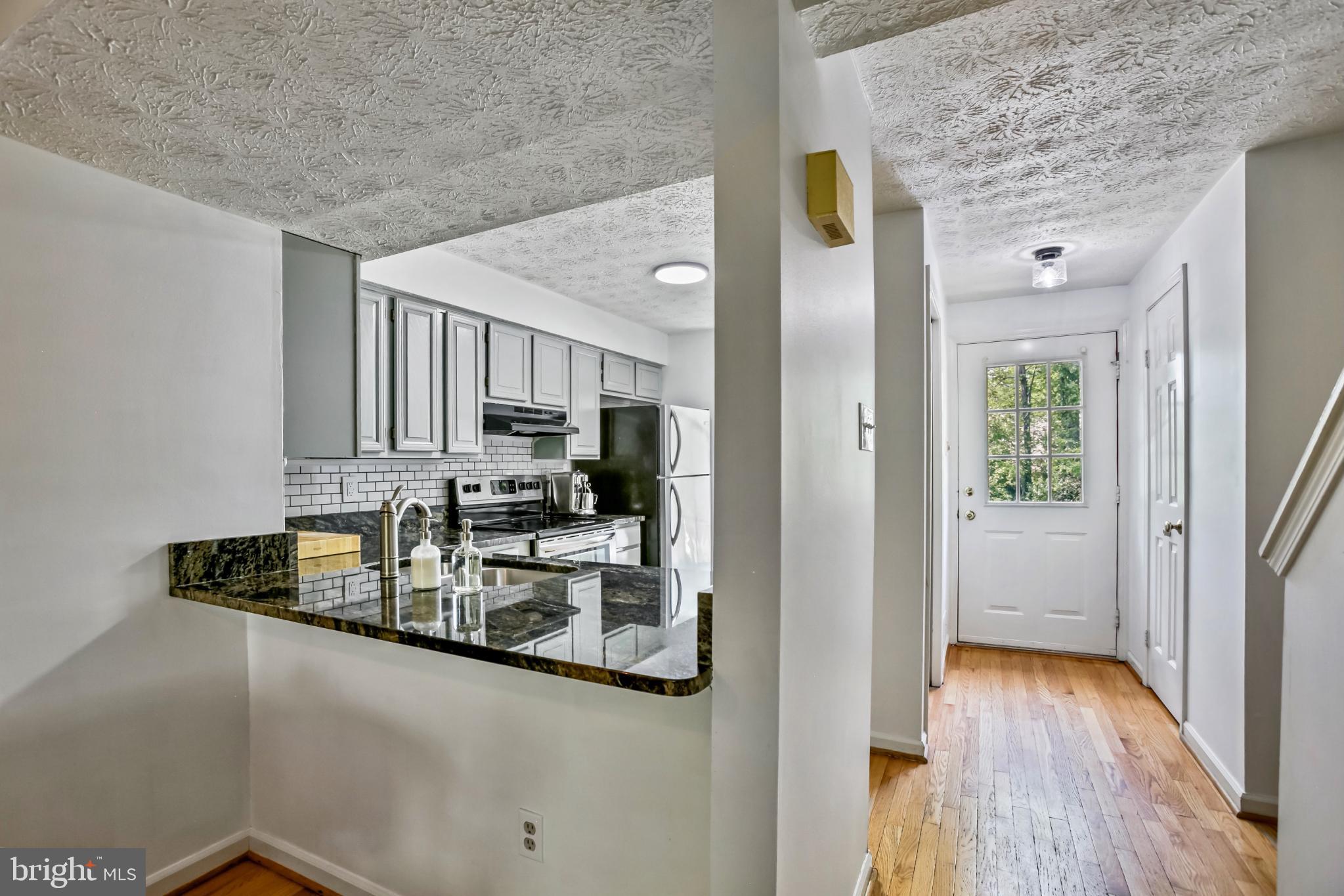 1675 Poplar Grove Drive Reston, VA 20194 - Photo 2 of 32 a kitchen with kitchen island granite countertop a refrigerator and a sink