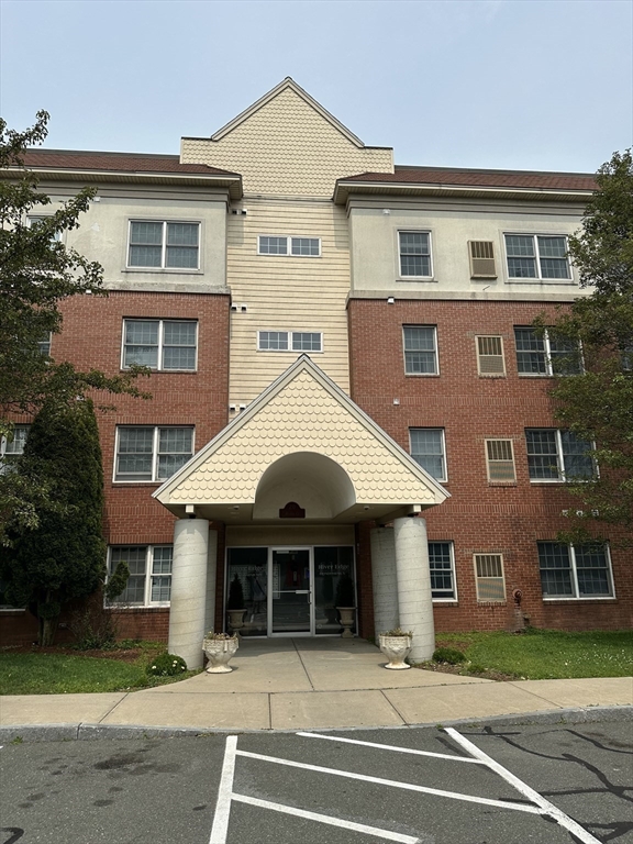 20 Heaths Court, Unit 309 Lynn, MA 01905 - Photo 2 of 18 a front view of a house with a yard and a garage