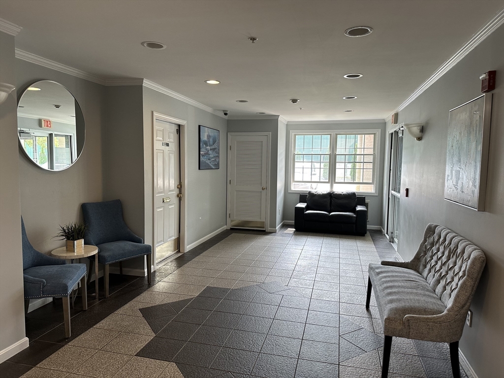 20 Heaths Court, Unit 309 Lynn, MA 01905 - Photo 3 of 18 a living room with furniture and a large mirror next to a window