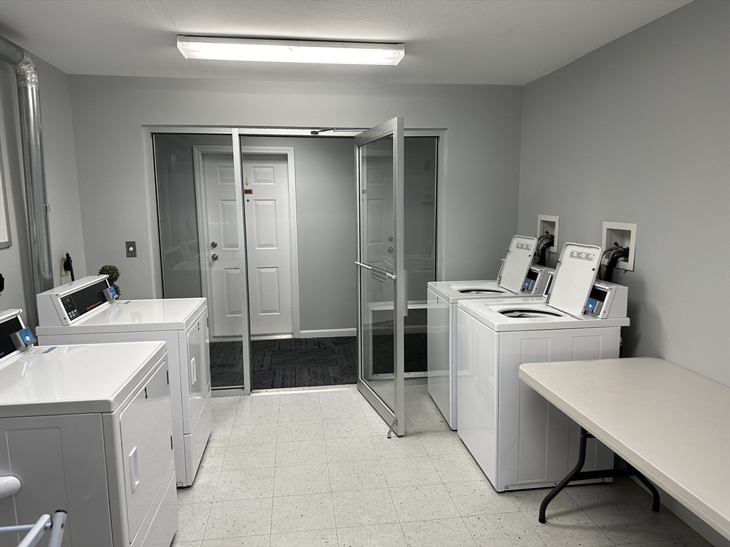 20 Heaths Court, Unit 309 Lynn, MA 01905 - Photo 5 of 18 a kitchen with a stove a sink a table and chairs