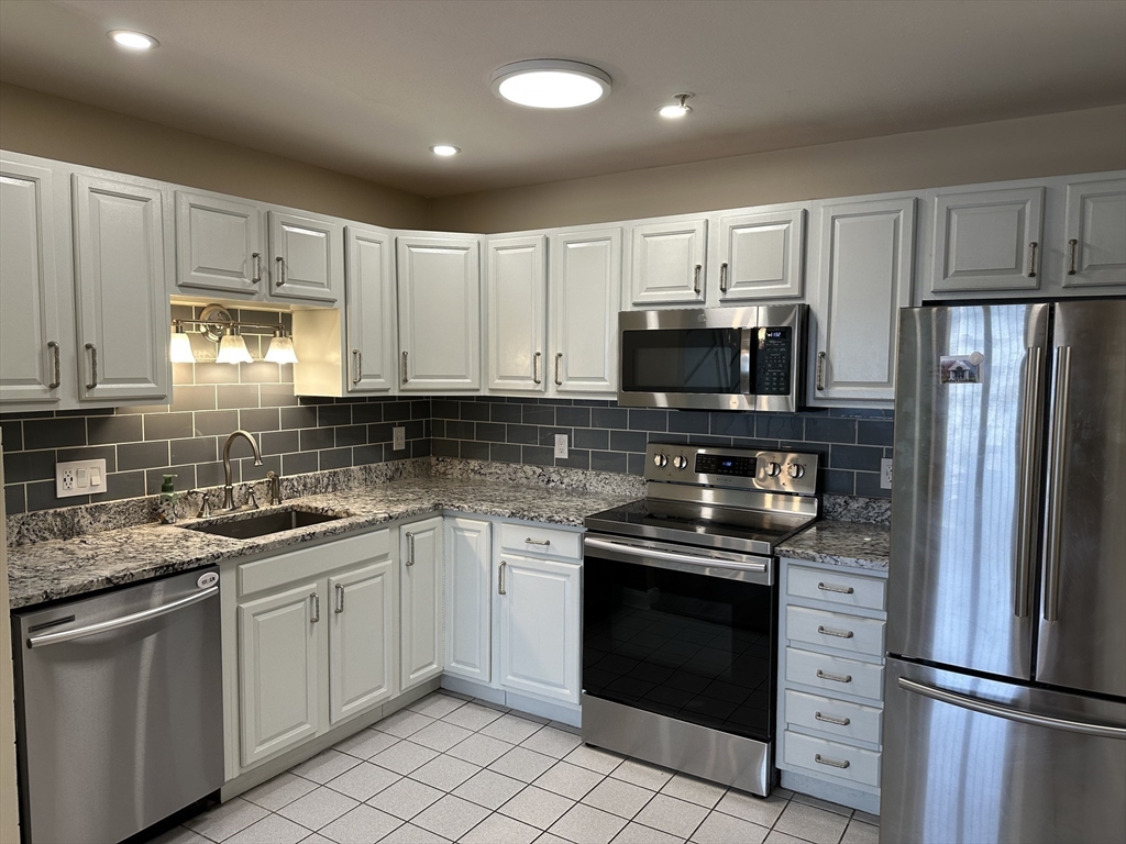 20 Heaths Court, Unit 309 Lynn, MA 01905 - Photo 6 of 18 a kitchen with stainless steel appliances granite countertop a stove a sink and a microwave