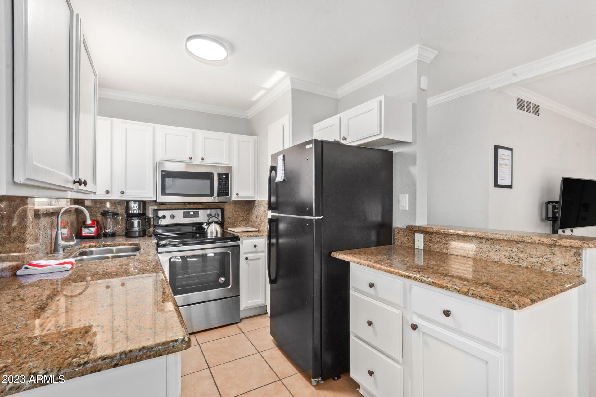 4401 North 12th Street, Unit 120 Phoenix, AZ 85014 - Photo 7 of 21 a kitchen with granite countertop a refrigerator and a stove top oven