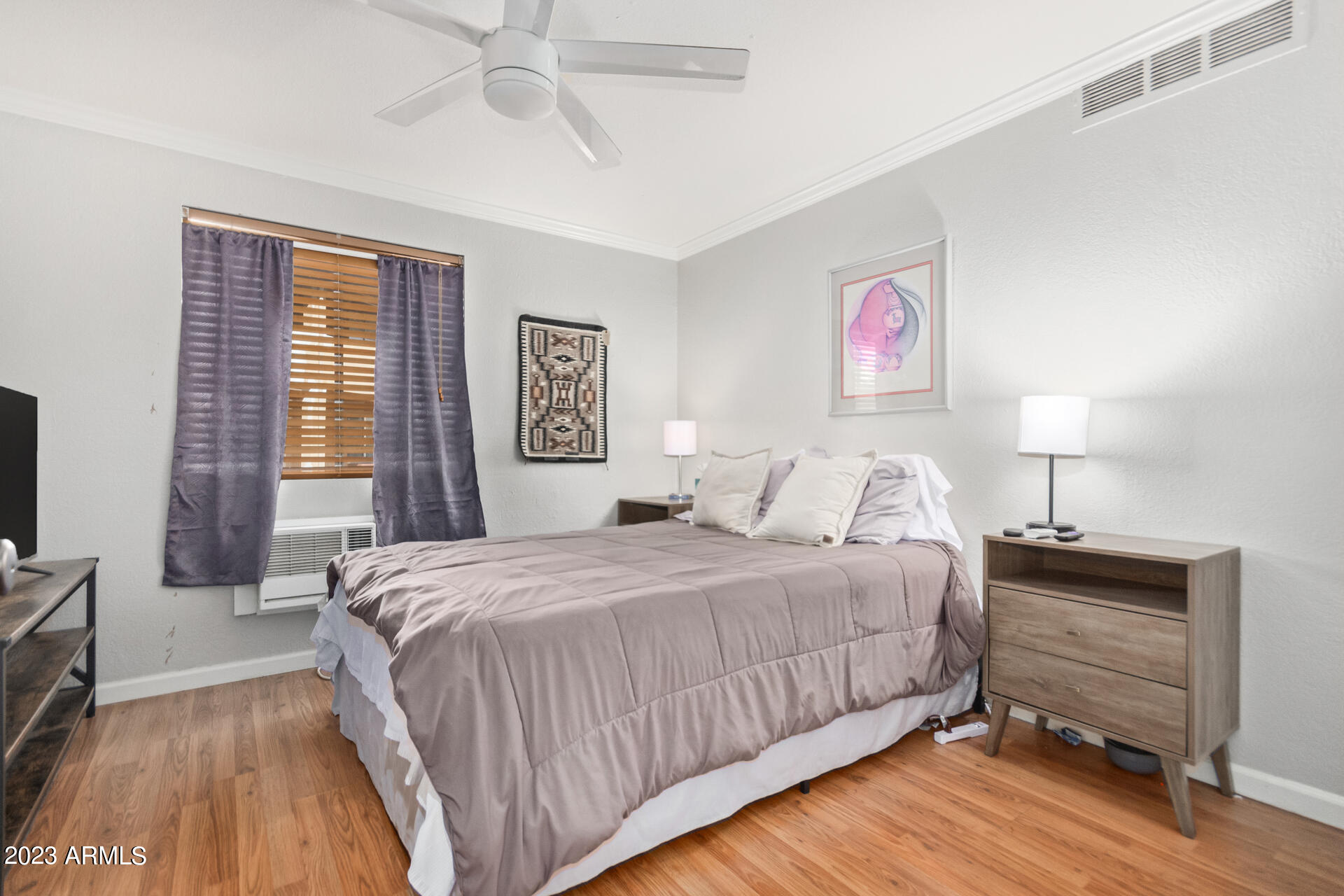 4401 North 12th Street, Unit 120 Phoenix, AZ 85014 - Photo 9 of 21 a bedroom with a bed and a flat tv screen on dresser