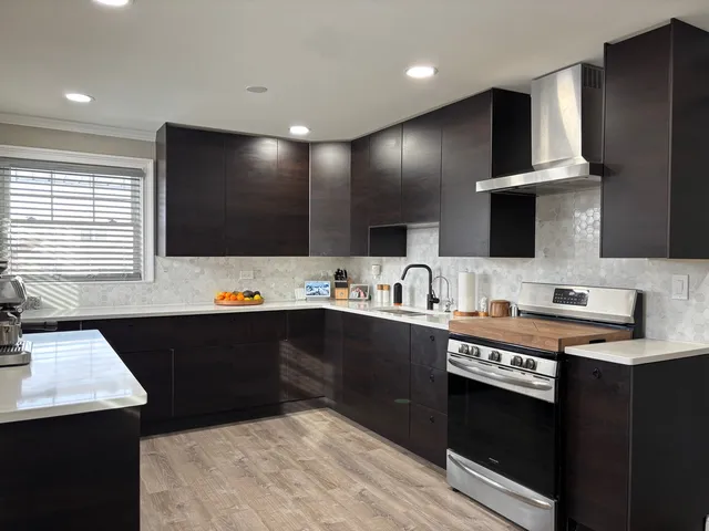 a kitchen with a refrigerator and a stove top oven