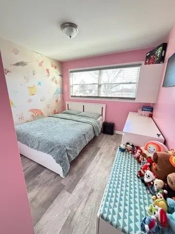 a bedroom with a bed dresser and a window