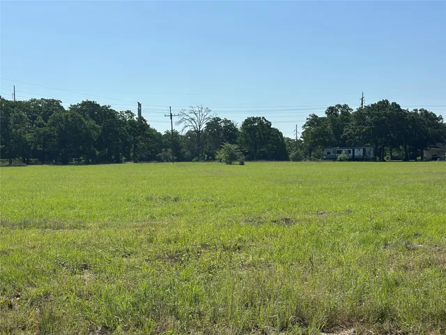 a view of open field with trees in background