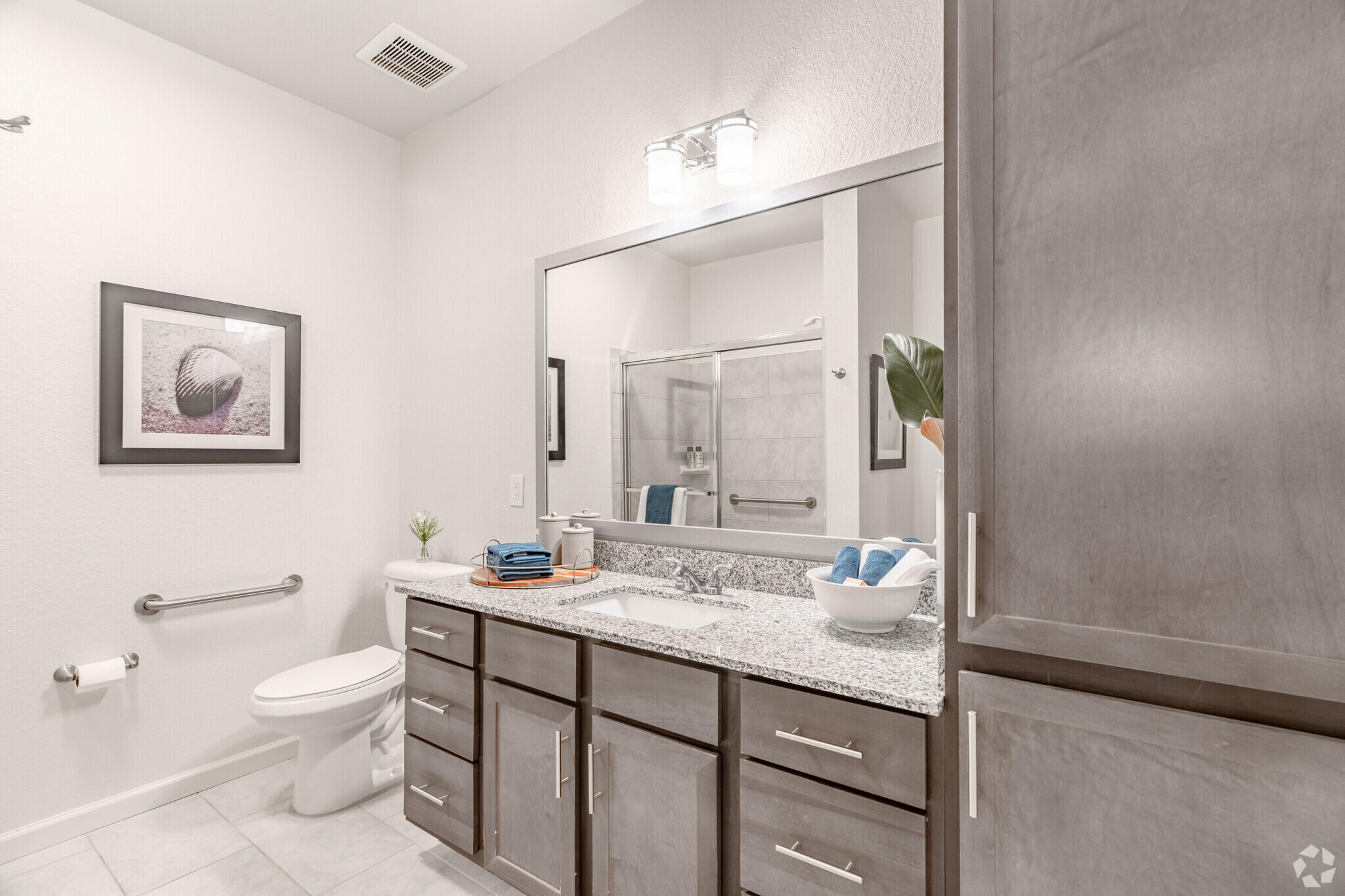 1924 Northwest Federal Highway, Unit 2317 Stuart, FL 34994 - Photo 9 of 15 a bathroom with a granite countertop sink a toilet and a mirror