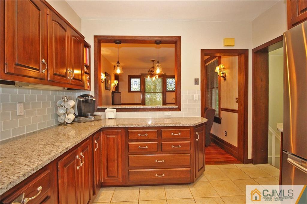 76 Rector Street Metuchen, NJ 08840 - Photo 6 of 25 a kitchen with stainless steel appliances granite countertop a stove a sink and a refrigerator