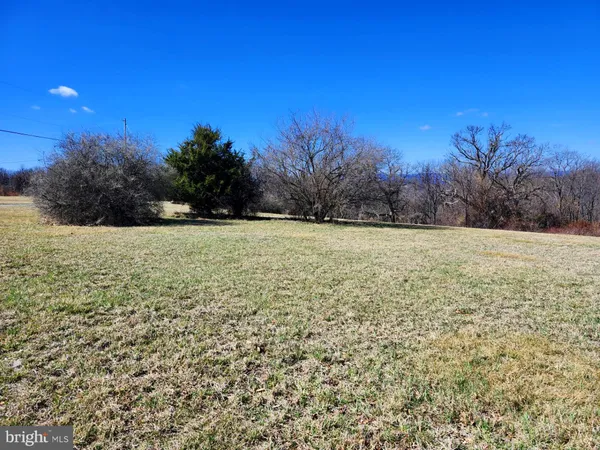 a view of lot of green field with trees in the background