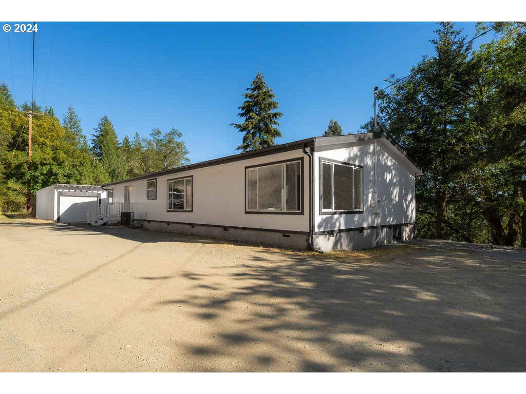 1069 Spring Brook Road Myrtle Creek, OR 97457 - Photo 2 of 43 a front view of a house with a garden