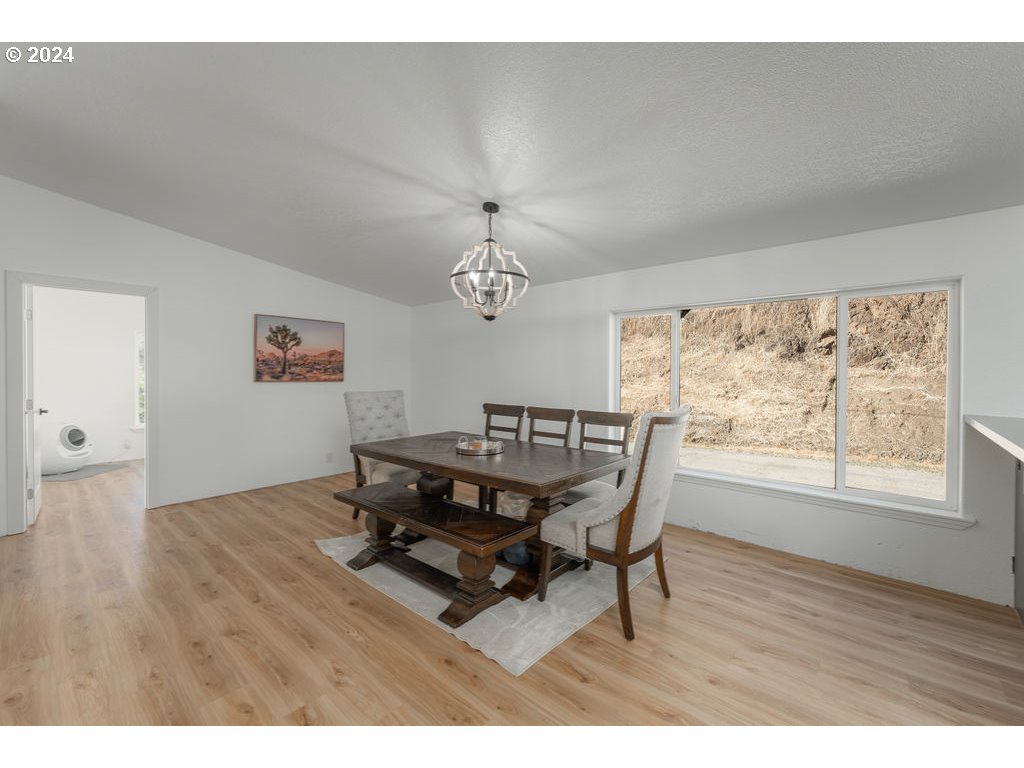 1069 Spring Brook Road Myrtle Creek, OR 97457 - Photo 10 of 43 a dining room with wooden floor and a chandelier