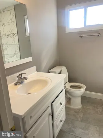 a bathroom with a toilet sink and mirror
