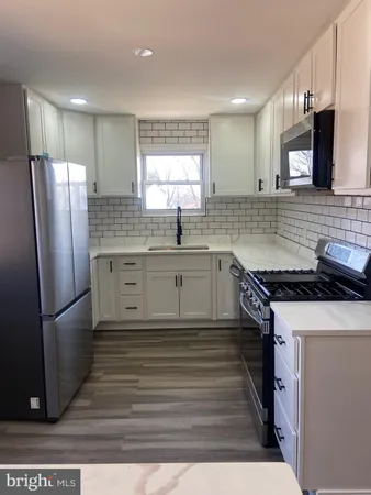 a stove top oven sitting inside of a kitchen