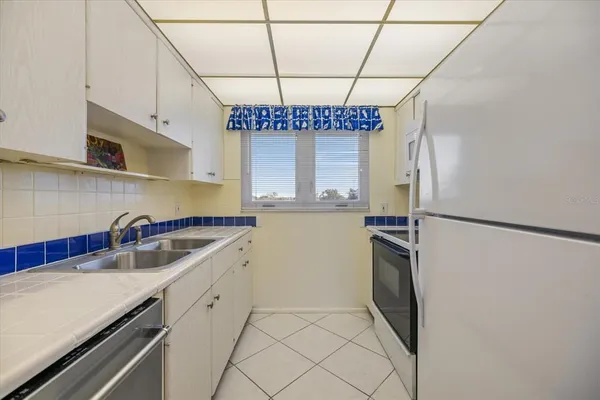 a kitchen that has a refrigerator and a sink
