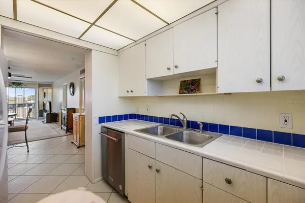 a kitchen with stainless steel appliances granite countertop a sink a stove and white cabinets