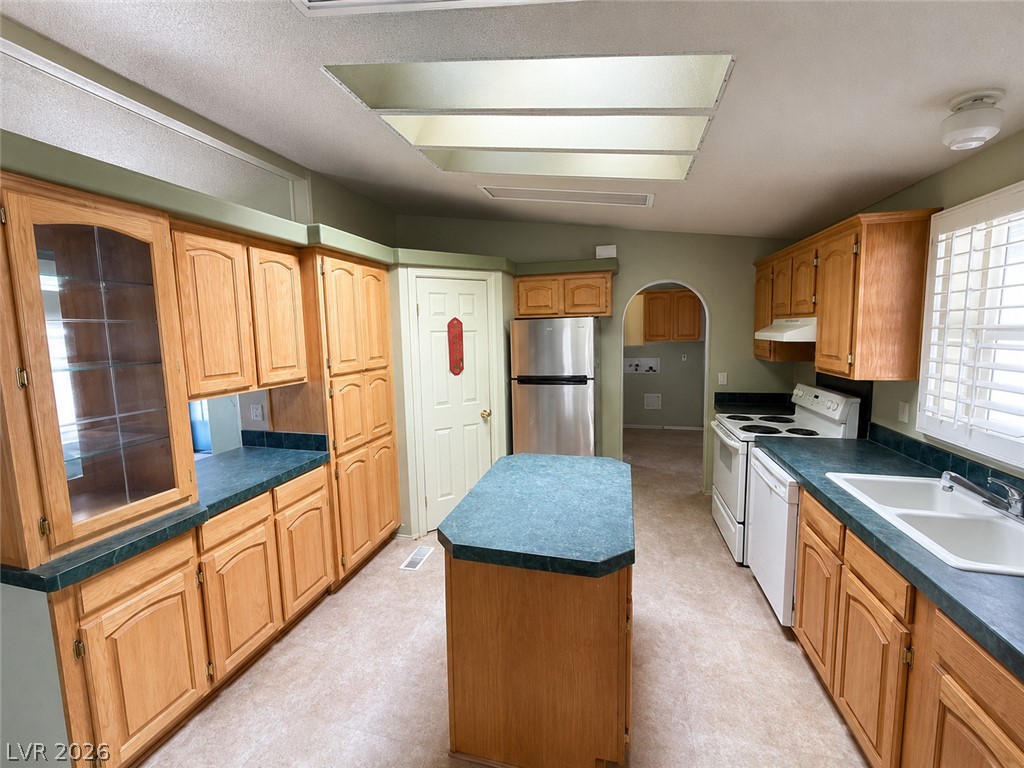 5561 Doubletree Road Pahrump, NV 89061 - Photo 5 of 19 Ample wooden cabinetry and a central island ground this skylit cooking space.