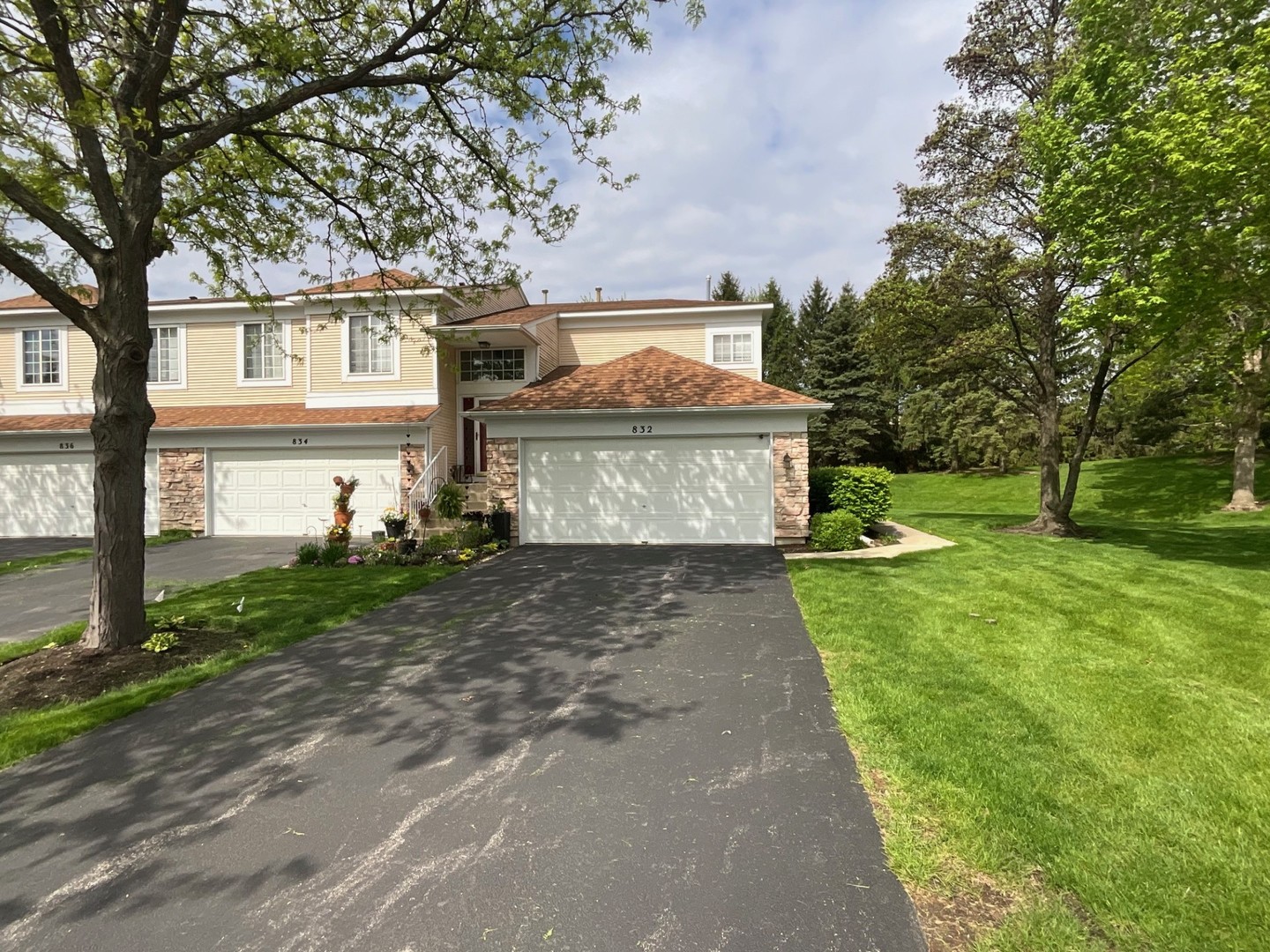 832 Coronado Court, Unit 832 Elgin, IL 60123 - Photo 2 of 20 a view of a white house with a big yard and large tree