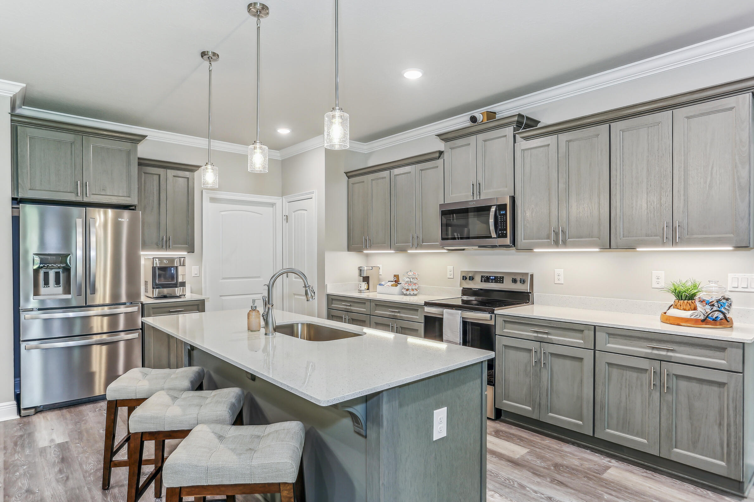 7568 Hatteras Drive Navarre, FL 32566 - Photo 20 of 44 a kitchen with a refrigerator a sink a stove a microwave and wooden cabinets
