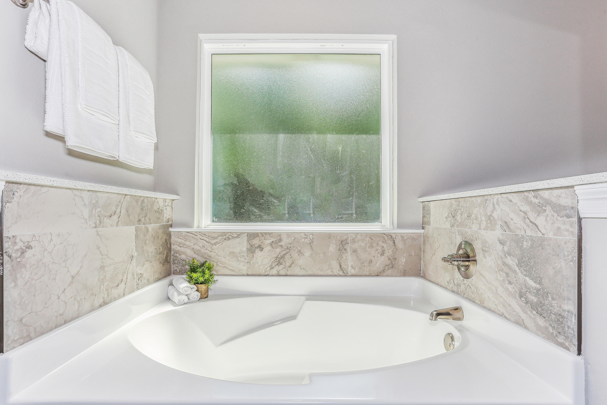 7568 Hatteras Drive Navarre, FL 32566 - Photo 31 of 44 a bathroom with a bathtub and a window