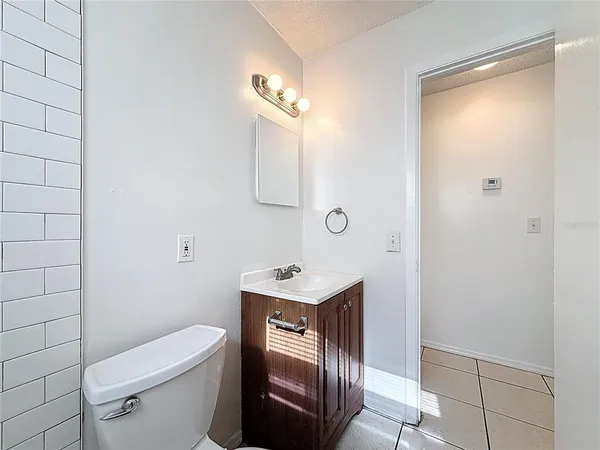 a bathroom with a toilet a sink a mirror and vanity
