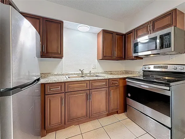a kitchen with granite countertop cabinets stainless steel appliances and a sink