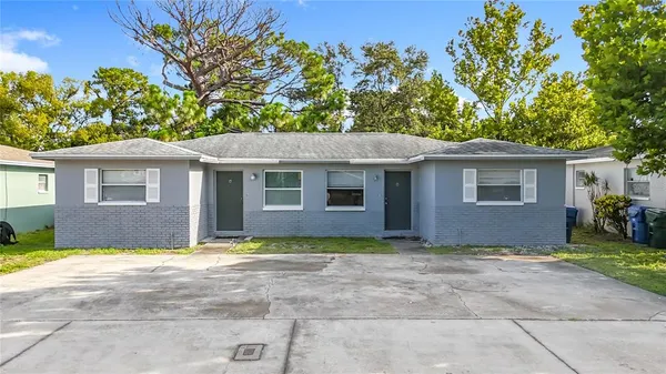 an aerial view of residential houses with city and green space