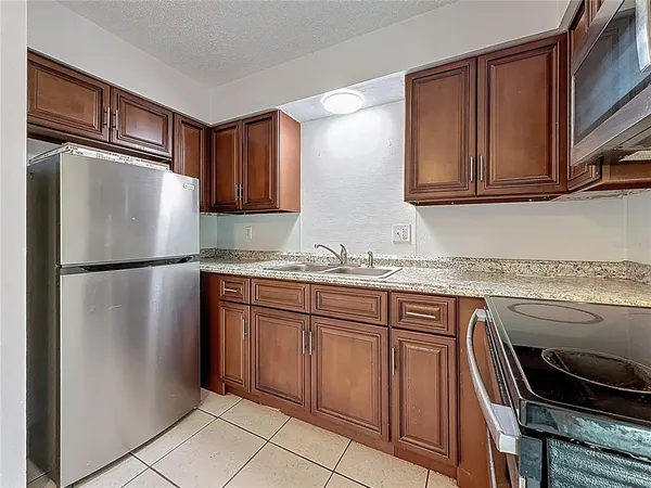 a kitchen with granite countertop stainless steel appliances and wooden cabinets
