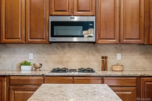 a kitchen with granite countertop wood cabinets and stainless steel appliances