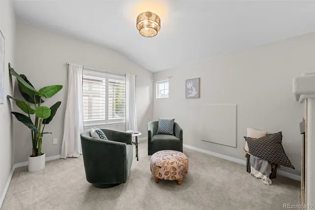 a living room with furniture a potted plant and a window