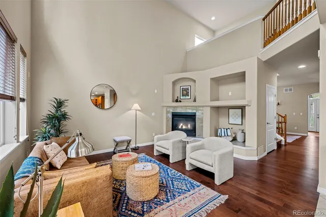 a living room with furniture a fireplace and a large window