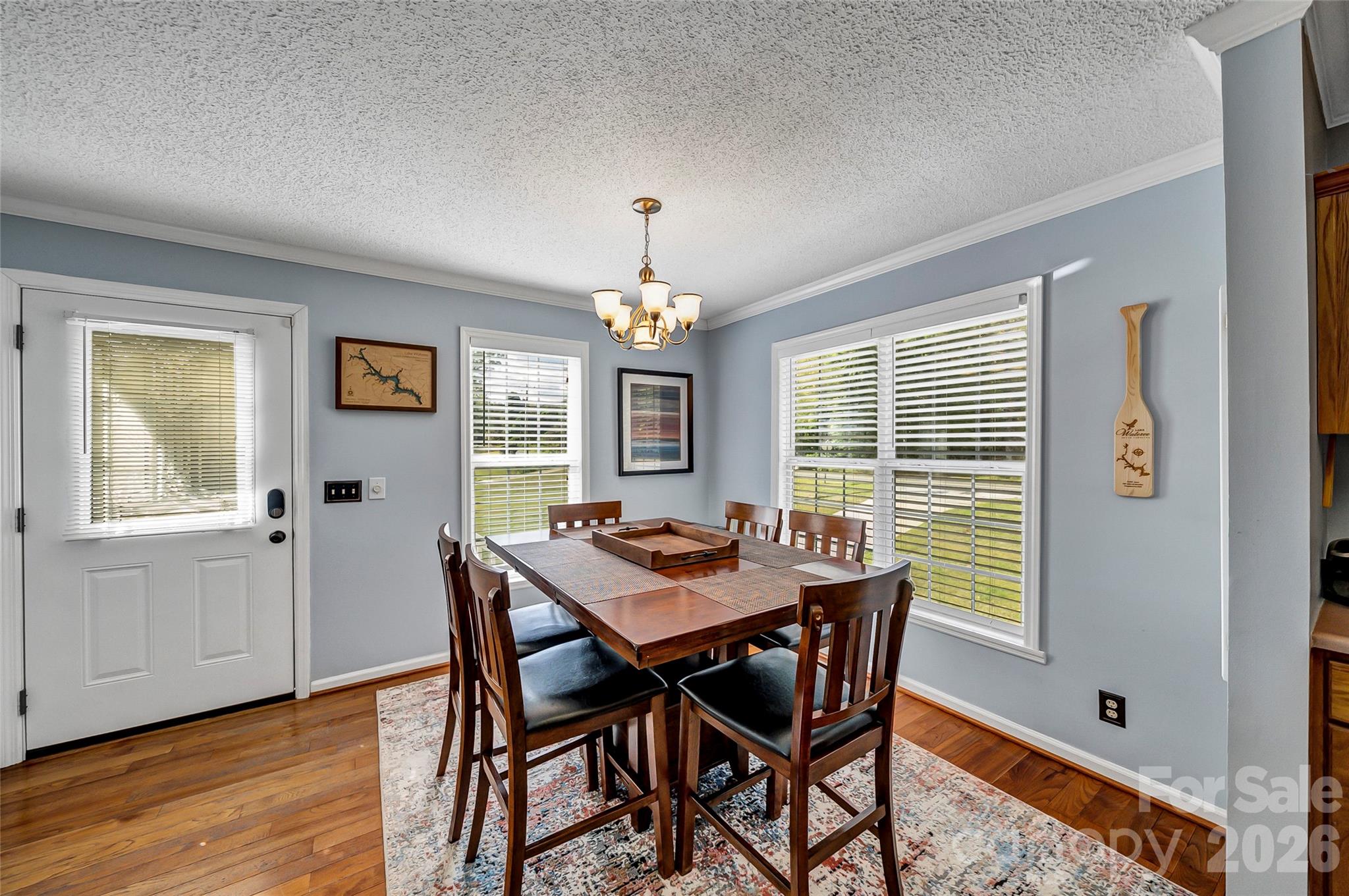 1273 State Rd S-20-317 Winnsboro, SC 29180 - Photo 17 of 48 a dining room with wooden floor a chandelier a wooden table and chairs