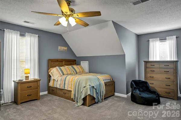 a bedroom with a bed and a ceiling fan