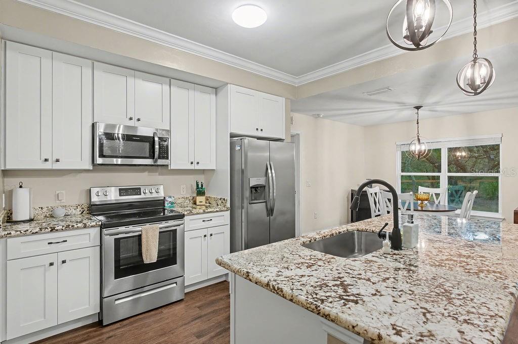 8291 Northeast 118th Terrace Bronson, FL 32621 - Photo 12 of 25 a kitchen with stainless steel appliances granite countertop a sink a stove and refrigerator