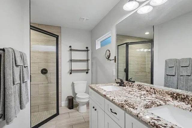 a bathroom with a granite countertop sink toilet and shower