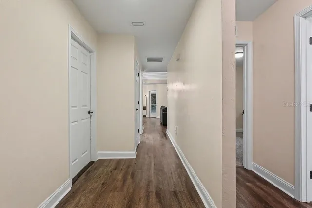 a view of a hallway with wooden floor