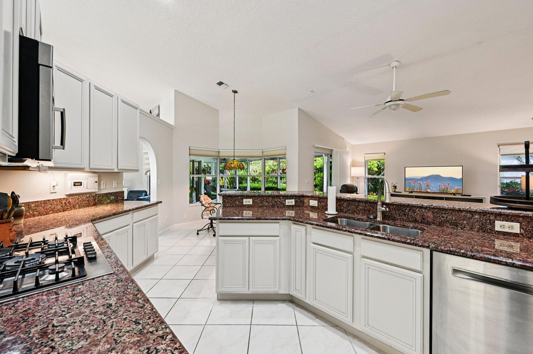 231 Sparrow Point Jupiter, FL 33458 - Photo 15 of 65 a kitchen with stainless steel appliances a sink stove and cabinets