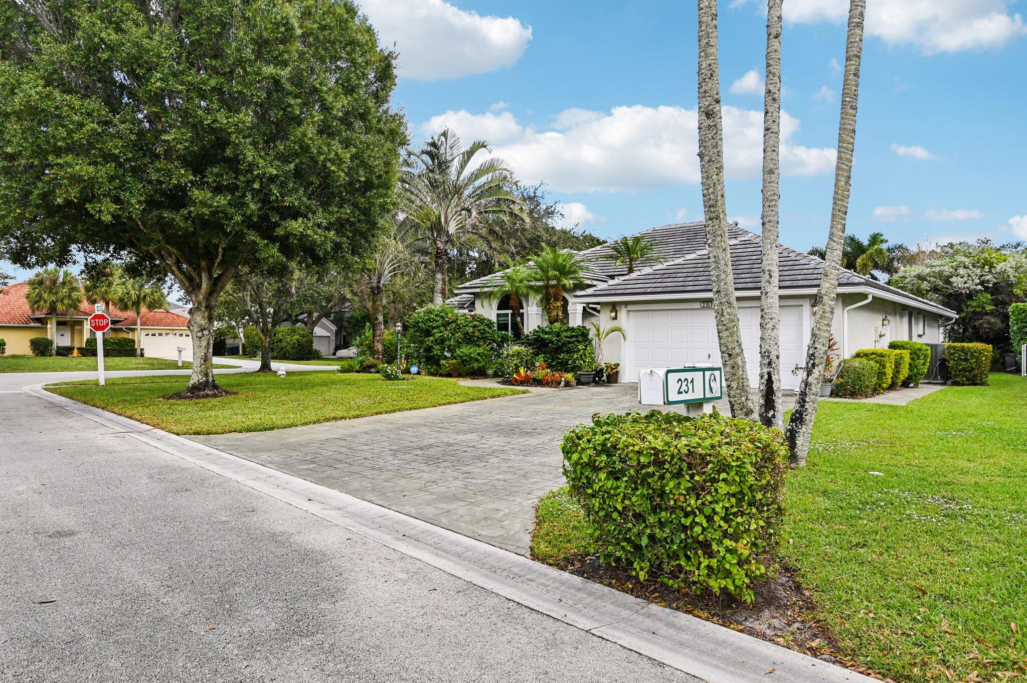 231 Sparrow Point Jupiter, FL 33458 - Photo 4 of 65 a view of a house with a big yard and large trees
