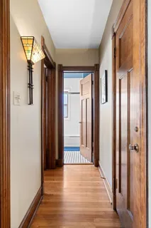 a view of a hallway with wooden floor and staircase