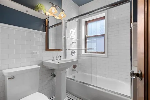 a bathroom with a sink mirror toilet and bathtub