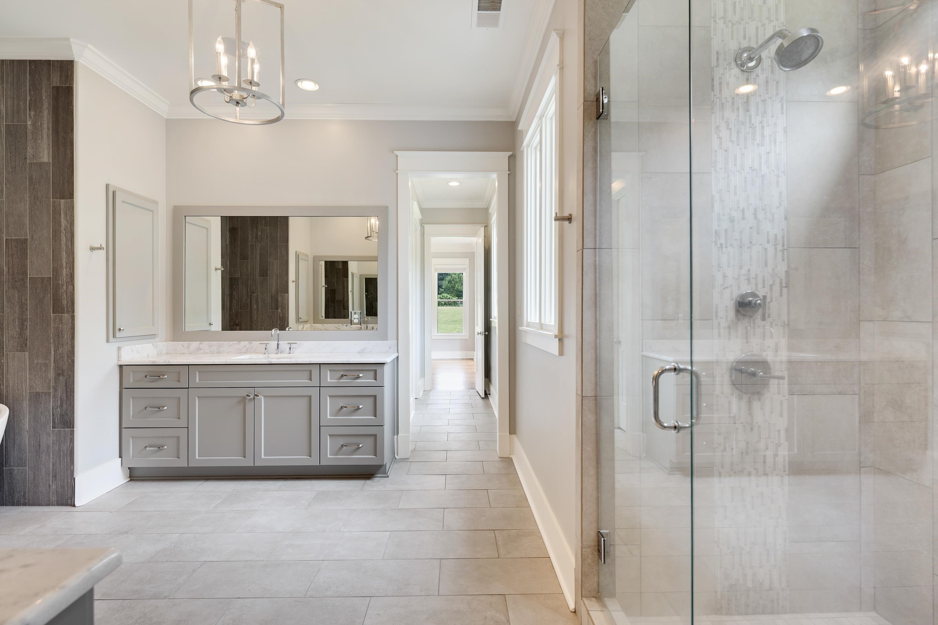 55 East Old State Line Road Piperton, TN 38017 - Photo 25 of 40 Spacious bathroom featuring a glass-enclosed shower, a double vanity with a stone countertop, light gray cabinetry, and a large wall mirror