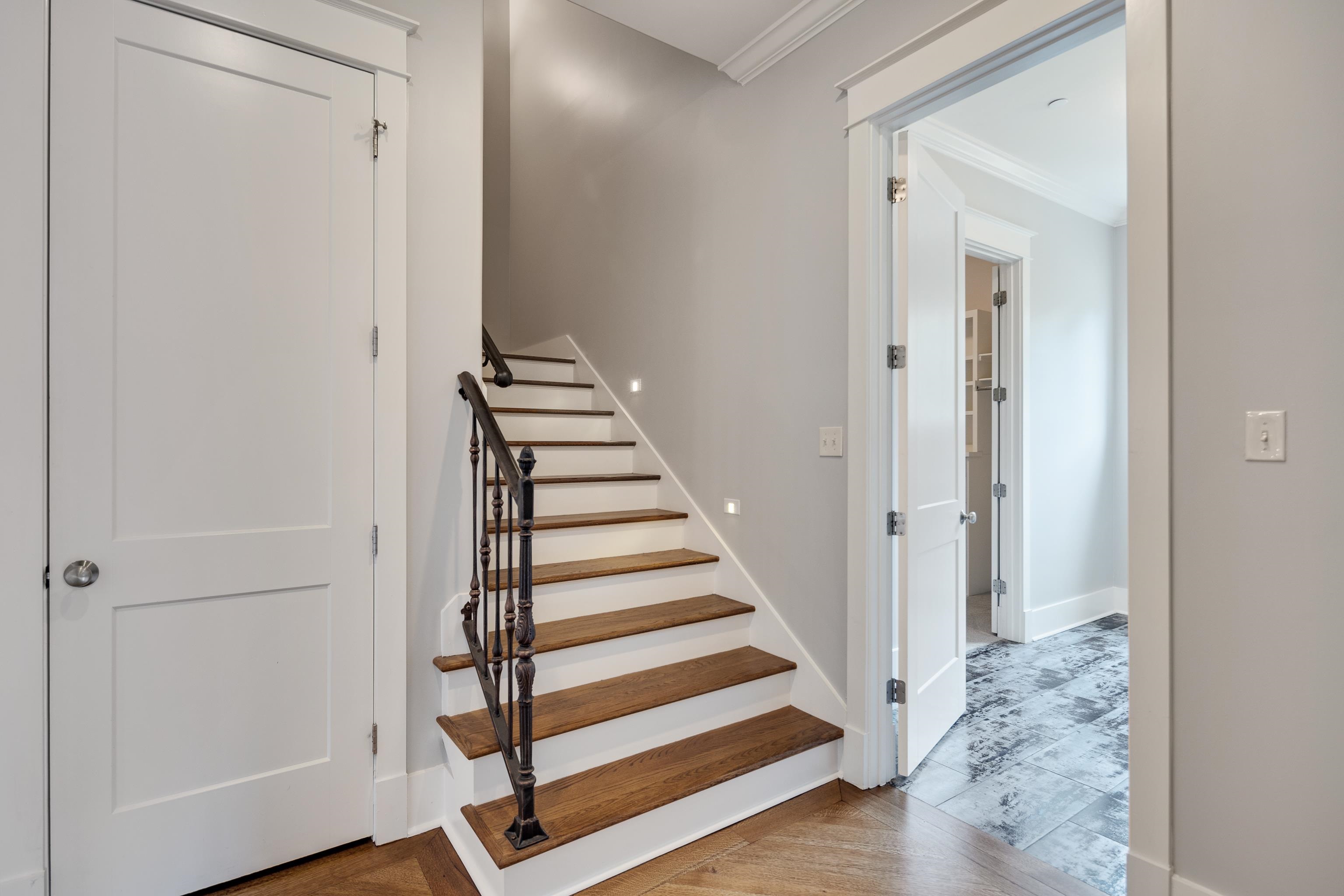 55 East Old State Line Road Piperton, TN 38017 - Photo 29 of 40 Herringbone wood-finish flooring complements the detailed staircase with dark wood treads and a wrought iron handrail