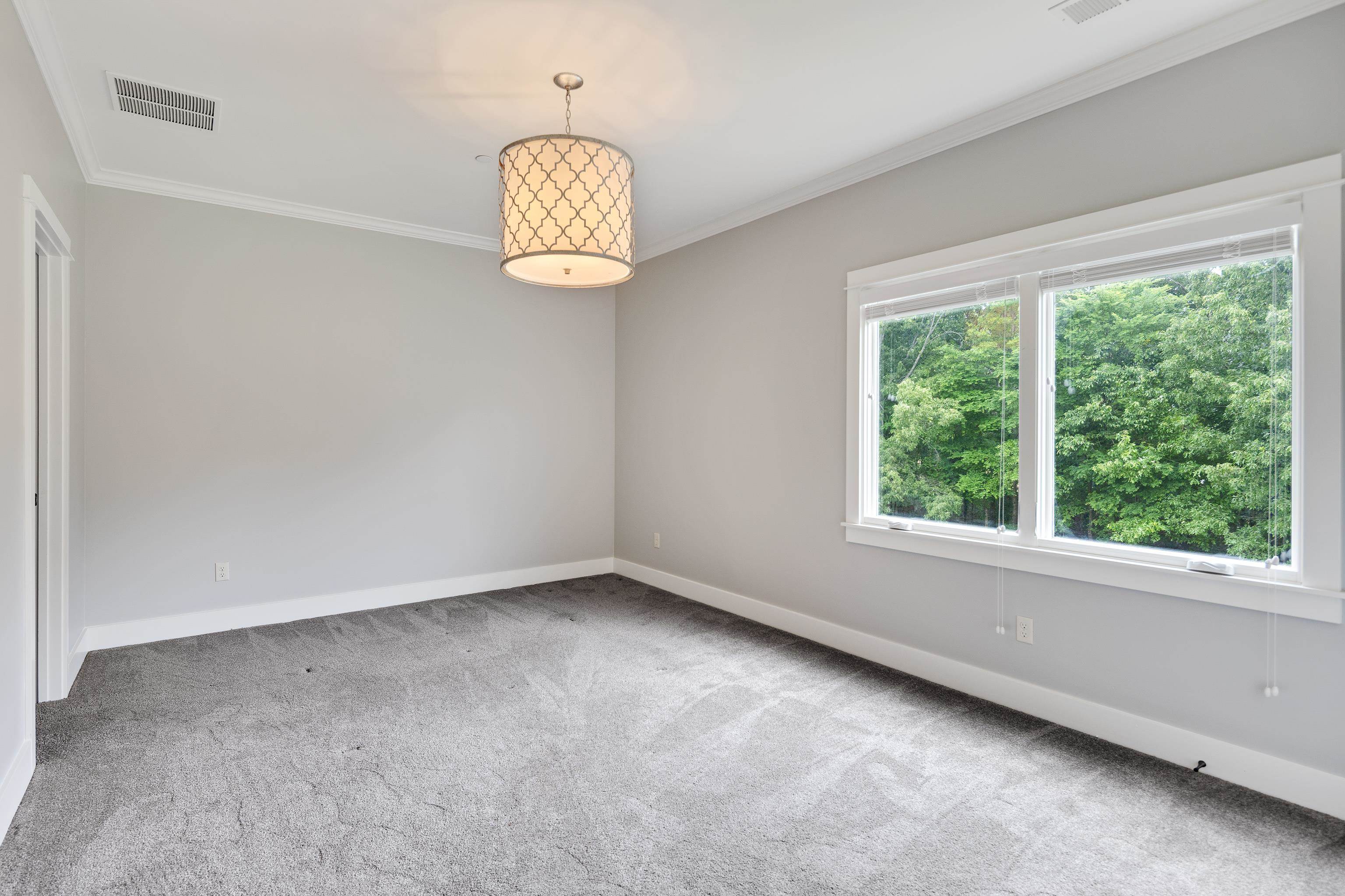 55 East Old State Line Road Piperton, TN 38017 - Photo 32 of 40 Bright interior space featuring a drum pendant light fixture, crown molding, and gray carpeting
